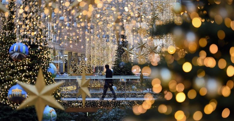 Человек идет по украшенному перед Новым годом городу