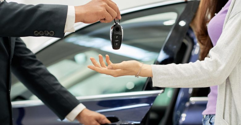 Продавец дает женщине ключи от автомобиля