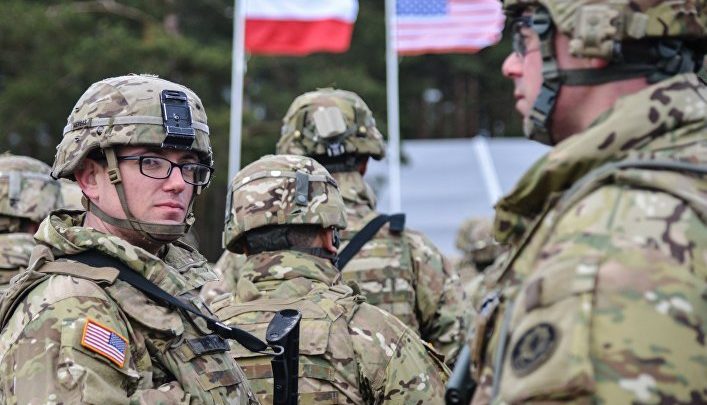 Американский солдат на фоне флагов США и Польши