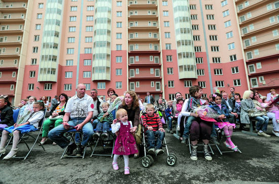 Множество семей с детьми во дворе дома