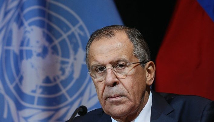 Глава МИД России Лавров на фоне флага ООН и России