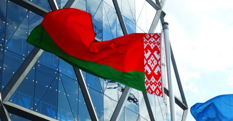 флаг Беларуси развивается на фоне высотного здания
