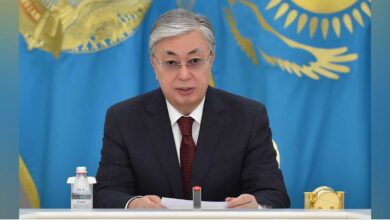 Токаев на фоне флага Казахстана